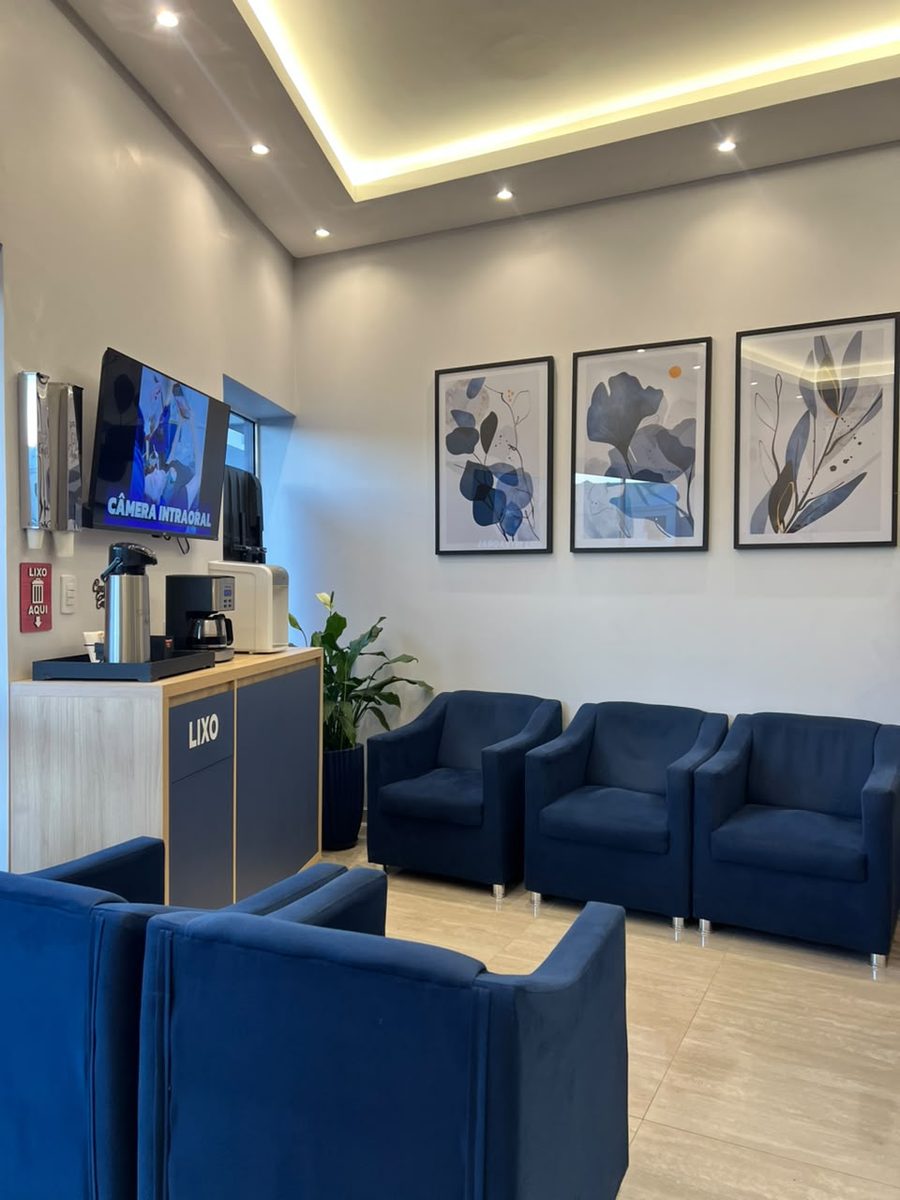 Sala de espera com poltronas e televisão - Clínica Odontológica Dr. Guilherme Peter Camaquã